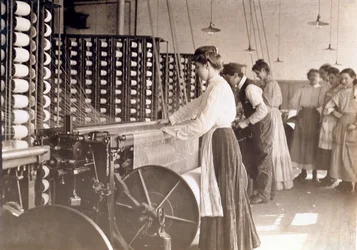 Unga kvinnor som arbetar vid en spinnmaskin i en bomullsfabrik i South Carolina, 1908