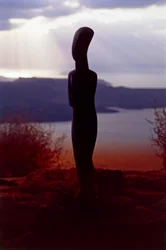 Kykladisk idol på bakgrund av kusten vid solnedgången, Kykladerna, Grekland, kykladisk civilisation (foto)