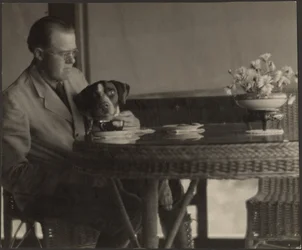 [Man och hund sitter vid ett bord]