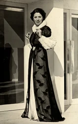 Modellen bär aftonklänning skapad av det italienska couturehuset "Bernasconi". Artikeln som presenteras består av en överrock i chiffong med pälskantad krage och manschetter (s/v foto)