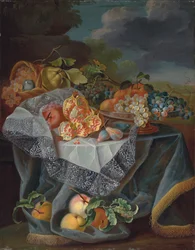 Vindruvor, päron och ett äpple på ett glaskärl, granatäpplen och en vävd korg med frukt på ett draperat bord och ett parklandskap bortom