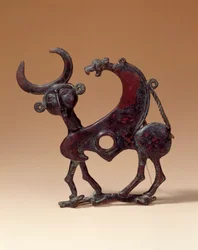 Orientaliska antikviteter: käftplatta i brons som visar ett androcefaliskt monster som trampar en då. Från Luristan. 750 f.Kr. Paris, Louvren