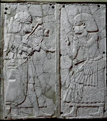 Fenicisk civilisation: sängornament dekorerat med en låg relief i elfenben som visar en vakt som förevisar ett lejon för kungen. Från fyndplatsen Ugarit, en forntida syrisk stad på Tell Ras Shamra. 1300-talet f.Kr. Mått 24 cm. Damaskus, Nationalmuseet