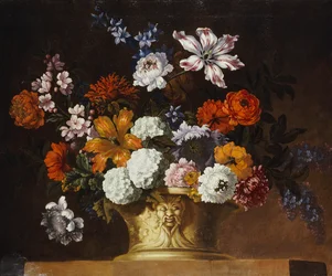 Tulpaner, snöbollar och andra blommor i en skulpterad urna på en avsats