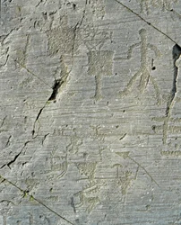 Förhistoria, Camunni-civilisationen, hällkonst: en gravhäll med scener av hjortjakt och vardagsliv i en by. Perioden mellan neolitikum och bronsåldern. Capo di Ponte, Parco nazionale delle incisioni rupestri di Naquane, Valcamonica, Val Camonica