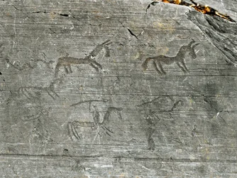 Förhistoria, Camunni-civilisationen, hällkonst: en ristad klippa med en jaktscen, en jägare svingar ett spjut. Perioden mellan neolitikum och bronsåldern. Capo di Ponte, nationalparken för hällristningarna i Naquane, Valcamonica, Val Camonica, Italien