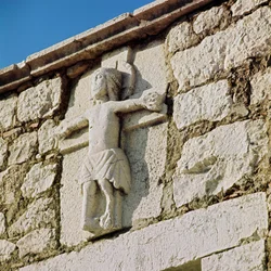 Kristus korsfäster stenskulptur från 1200-talet. Portal av den romanska kyrkan San Bartolomeo, Campobasso Italien