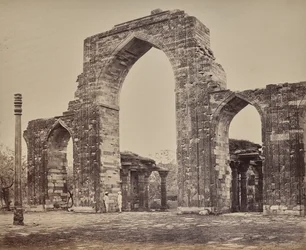Delhi. Stor båge och järnpelare nära Qutub Minar, ruinerna av gamla Delhi