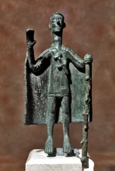 Sardisk nuragisk kultur (nuragher): bronsstatyett av en resenär som håller en käpp och är höljd i en mantel. 8:e-7:e århundradet f.Kr. Cagliari, Museo Nazionale Archeologico, Sardinien, Italien