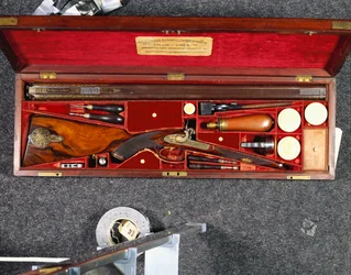 Gulddekorerat 16 pipigt D.B. slaggevär tillverkat för Nizam av Hyderabad, i mässingsmonterat mahognyfodral, fodrat med karmosinrött siden, ca 1855 (siden, mahogny, stål, koppar)