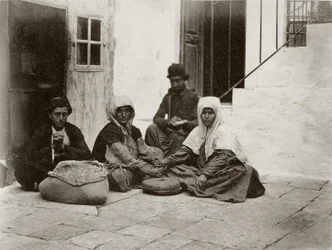 Kvinnor som maler mjöl med runda kvarnstenar på en innergård till ett hus i Jerusalem, 1867