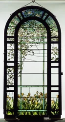Ett spaljerat fönster av blyglas som visar klematisrankor, tidigt 1900-tal (blyat glas)