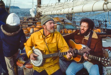 Musikern och miljökämpen Peter Seeger spelar banjo på däck på Clearwater i...