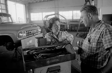 Lastbilschauffören Mildred Cooper pratar med mekanikern i ett garage