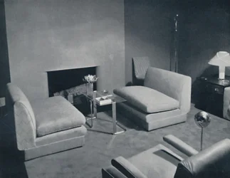 En grupp vid brasan i ett vardagsrum designad av Russel Wright, 1935