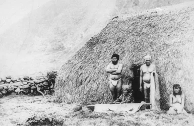 En gammal kvinna som slår tapa framför ett piligräshus, Kalaupapa, Hawaii, 1800-talet