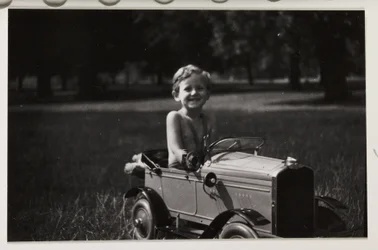 Pojke som kör en leksakstrampbil, c 1930
