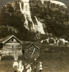 Barn som leker på en bonde åker med terrasserade Tvinde vattenfall, Vossevangen, Norge, c1905.