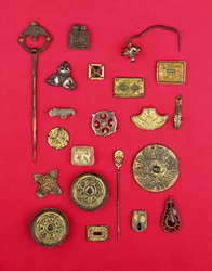 Samling av anglosaxiska och keltiska smycken inklusive fästen i förgylld brons, fat och korsformade broscher och ett merovingerhänge, från 1:a till 700-talet e.Kr. (brons)