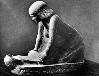 Egyptisk gravfigur av en kvinna som maler majs med hjälp av en sadel quern, c2500 f.Kr.