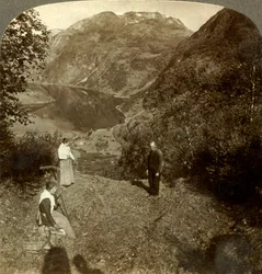 Höja på bergshyllan högt över byn Marok och spegelklara Geirangerfjorden, Norge, c1905