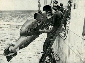 Att hissa en stridsbemannad torped ombord på ett fartyg, andra världskriget, 1945.