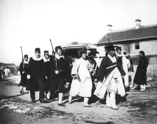 Japansk tjänsteman med en eskort av soldater, Korea, ca 1900