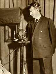 John Logie Baird tittar på den första pjäsen som sänds på tv, 14 juli 1930, 1935.