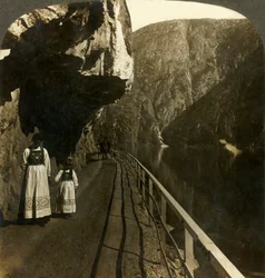 Smal stenhylla där vägen till Voring Falls förbi sjön Oifjords djupa vatten, Norge, c1905.