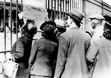 Flyktingar som studerar en tågtidtabell, Gare de lEst, Paris, juli 1940
