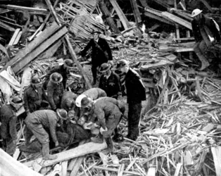 Räddningsarbetare som släpper en man från en bombskadad byggnad, andra världskriget, 1940