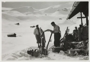 Skidåkare utanför en stuga, ca 1930