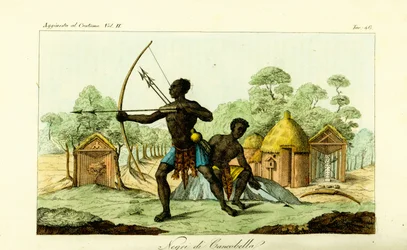 Två Luanda-män från Cancobella, Angola, med bågar och pilar, framför bostäder, hyddor, heliga fetischaltare, etc.