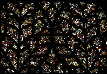 Abstrakta mönster av fragment av målat glas från 1200-talet i Bishops eye window, South Rose