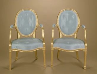 Ett par Adam-stolar med ovalryggade förgyllda carver, blåklädda, ca 1780