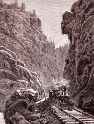 Ett tåg korsar Colorado-bergen. U.S.A. år 1886 (gravyr)