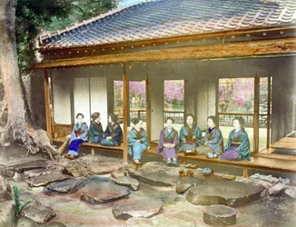 Japan omkring 1890. Japanska kvinnor i en trädgård. Handkolorerat fotografi från omkring 1890.