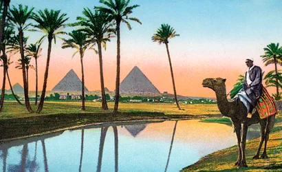 Man på kamel tittar på pyramiderna i Gizeh, ca 1900 (kromolit)