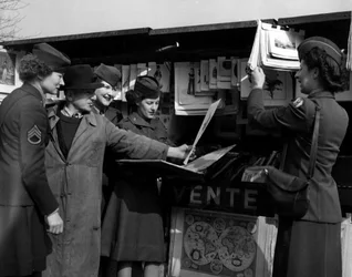 Andra världskriget (1939-1945) - Andra världskriget (WWII eller WW2): Paris (Frankrike) Mars 1945: Four Wacs (Women Army Corps) från den amerikanska armén diskuterar med en bokspelare på stranden av Seine.