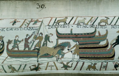 Erövra England av hertigen av Normandie Vilhelm Erövraren (1027-1087) 1066: Normandiska fartyg seglar på den engelska kusten. Hästen drar båten på korridoren. Detalj av Bayeuxtapet eller broderi av drottning Mathilde