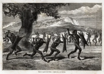 Obbos (stam av Uganda) utför en krigsdans. Gravyr för illustration av resan till Lake Albert, 1861-1864, av Sir Samuel White Baker, i "Le tour du monde, nouveau journal des voyages"" publicerad under ledning av Edouard Charton