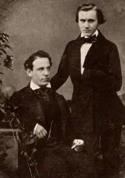 Johannes Brahms (1833-1897), tysk kompositör, stående, med den ungerske flyktingviolinisten Eduard Remenyi (1828-1898), som han turnerade med (raster från ett fotografi)