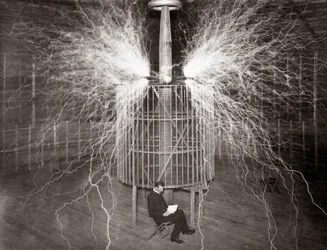 Nikola Tesla sitter i sitt laboratorium i Colorado Springs med sin "förstoringssändare"