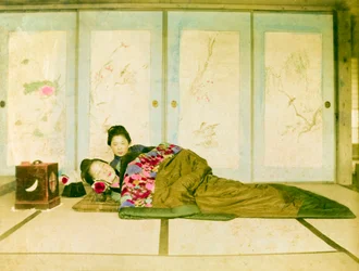 Liggande på en futon. Två japanska kvinnor ligger på en traditionell futon som är placerad på golvet. Japan, cirka 1910. Japan, Östra Asien, Asien. ©Cultural Heritage Images/UIG/Leemage