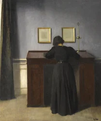 Ida står vid ett skrivbord, 1900