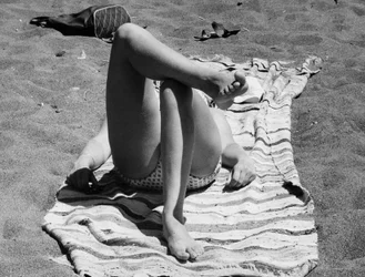 Kvinnliga ben på en strand, ca 1960 (svartvitt foto)