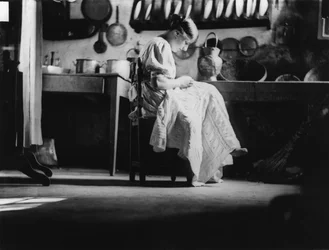 Flicka syr linne till sin hemgift, ca 1916 (svartvitt foto)