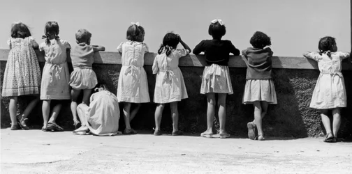 Grupp barn som lutar sig mot ett räcke, Italien, ca 1960 (gelatinsilvertryck)