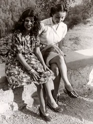 Två flickor sittande på en vägg, Italien, ca 1940 (svartvitt foto)