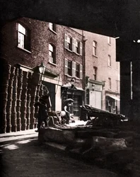 Fruktkorgar staplade mot hus på Borough Market, London, 1926-1927